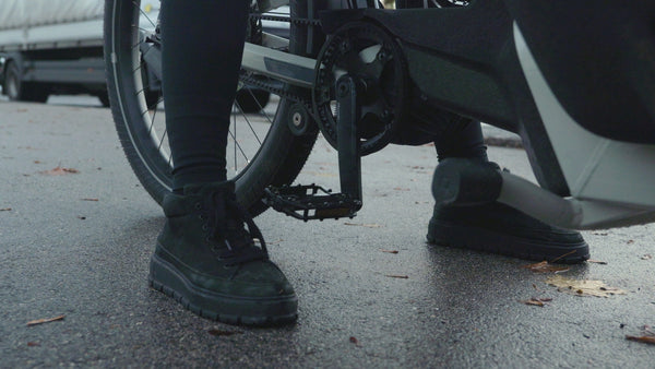 Beine einer Mutter mit Bodenkontakt welche auf einem Cago FS200 Cargo Bike mit Eightpins Sattelstütze sitzt. Es soll gezeigt werden, dass absenkbare Teleskopsattelstützen in urbanen Bikes die Sicherheit und den Komfort erhöhen wenn die Beine beim stehen bleiben den Boden erreichen können.