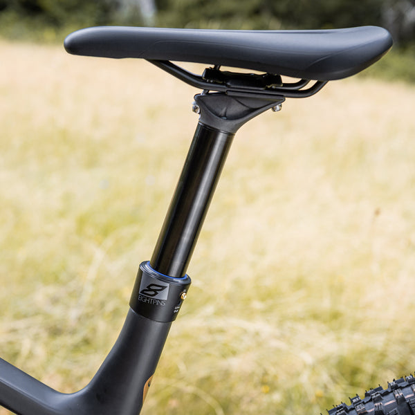 Bild zeigt eine Eightpins H01 Sattelstütze verbaut in einem Rotwild 375 Bike mit einem Kornfeld im Hintergrund.