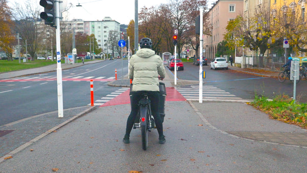 Foto von Mutter von hinten aufgenommen auf einem CAGO FS200 Cargo bike mit abgesenkter Eightpins NGS2 Cargo Sattelstütze und beiden Beinen am Boden.