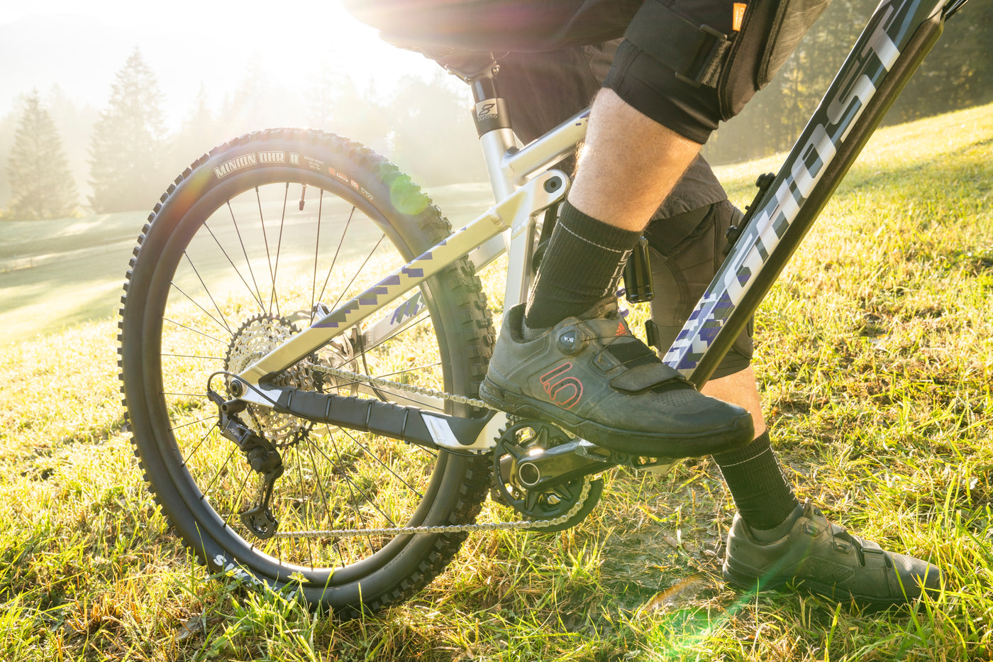 Beine eines Fahrers der auf einem Ghost Riot Full Party Bike sitzt und der hintere Teil eines Bikes mit einer Eightpins Sattelstütze.